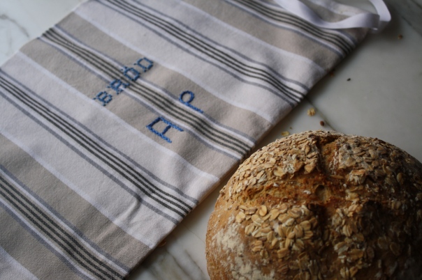 Fresh Bread Covered With A Checkered Towel On A Rustic Kitchen